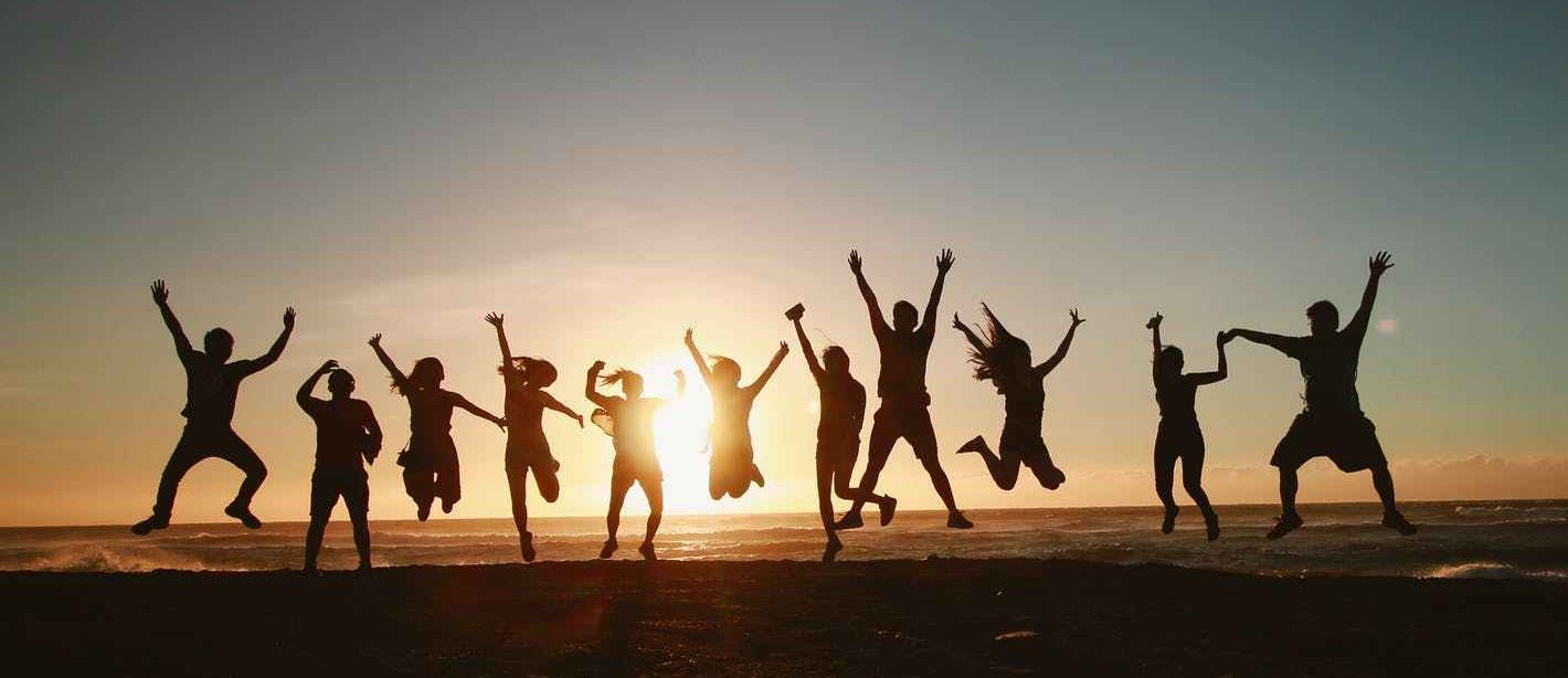 silhouette photography of group of people jumping during golden time